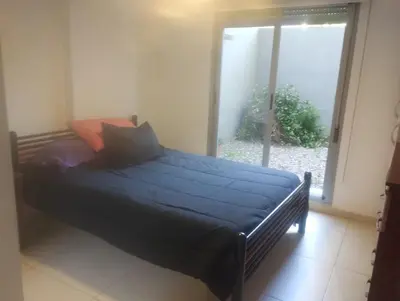 a bedroom with a bed with blue sheets and a window at Confort en Barrio General Paz in Cordoba