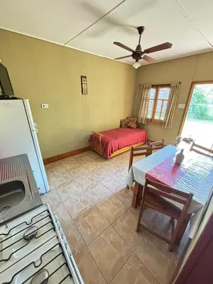 a living room with a bed and a table in it at Las Casitas De Moni in Villa del Dique