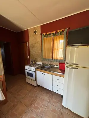 a kitchen with a white refrigerator and a sink at Las Casitas De Moni in Villa del Dique