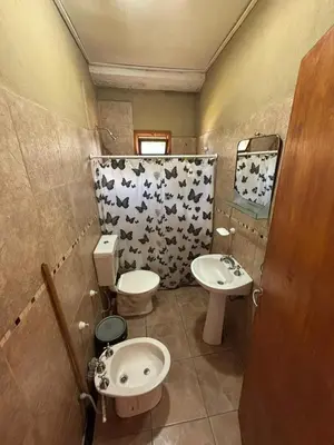 a small bathroom with a toilet and a sink at Las Casitas De Moni in Villa del Dique
