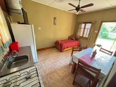 a kitchen with a sink and a refrigerator and a table at Las Casitas De Moni in Villa del Dique