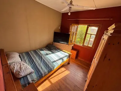 a small bedroom with a bed and a window at Las Casitas De Moni in Villa del Dique