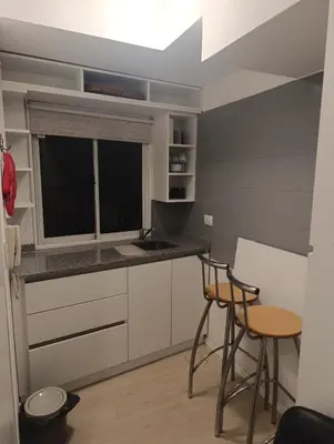 a kitchen with two stools and a counter with a window at departamento amoblado en Nueva cba-a metros de la terminal omnibus in Cordoba