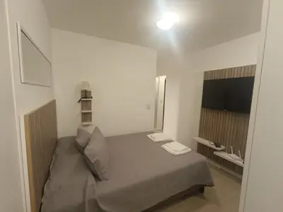 a small bedroom with a bed and a television at departamento amoblado en Nueva cba-a metros de la terminal omnibus in Cordoba