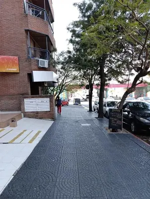a person walking down a sidewalk next to a building at departamento amoblado en Nueva cba-a metros de la terminal omnibus in Cordoba