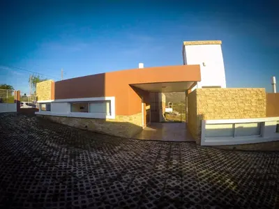 a building with an open door on the side of it at Complejo de Cabañas Coquena in San Antonio de Arredondo