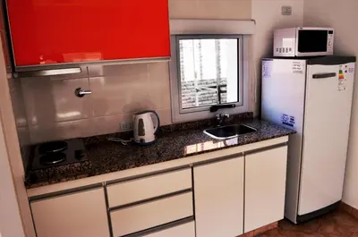 a small kitchen with a refrigerator and a sink at Complejo de Cabañas Coquena in San Antonio de Arredondo