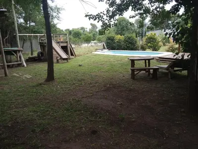 a park with a picnic table and a swimming pool at Cabañas Solar de las Viñas in Villa Los Molinos