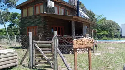 a wooden house with a fence in front of it at Cabañas Solar de las Viñas in Villa Los Molinos