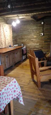 a room with a table and chairs and a kitchen at Cabañas Solar de las Viñas in Villa Los Molinos