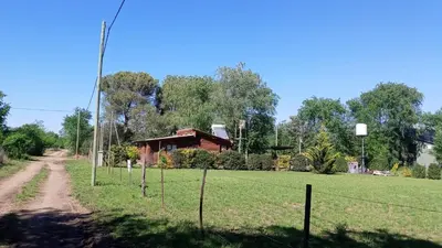 a house with a fence in front of a field at Cabañas Solar de las Viñas in Villa Los Molinos