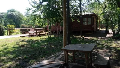 a wooden bench sitting in front of a cabin at Cabañas Solar de las Viñas in Villa Los Molinos