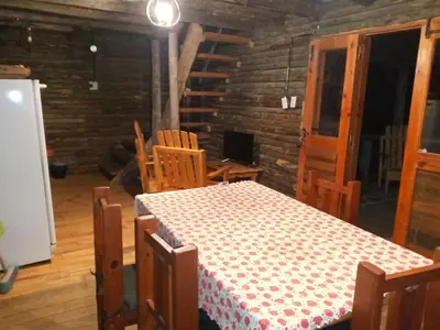 a dining room with a table and chairs in a room at Cabañas Solar de las Viñas in Villa Los Molinos
