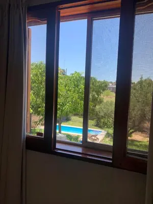 a window with a view of a pool seen through it at Casa Maru in Villa Carlos Paz