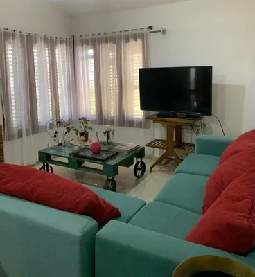 a living room with two blue couches and a tv at Casa Maru in Villa Carlos Paz