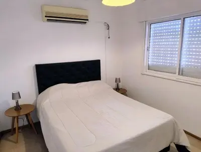 a bedroom with a white bed and a window at Chalet House - Villa Carlos Paz in Villa Carlos Paz