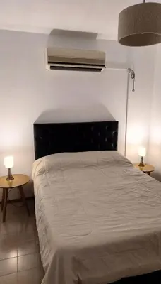 a bedroom with a large bed with two tables at Chalet House - Villa Carlos Paz in Villa Carlos Paz