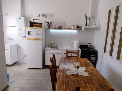 a kitchen with a wooden table and a refrigerator at Chalet House - Villa Carlos Paz in Villa Carlos Paz