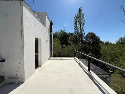 a balcony of a white building with trees in the background at Poseidon in Las Chacras (La Paz)