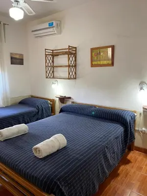 two beds in a room with blue sheets at Are-Kepay in Villa Carlos Paz