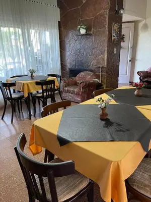 a dining room with tables and chairs with yellow table cloth at Are-Kepay in Villa Carlos Paz
