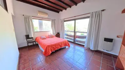 a bedroom with a bed with a red blanket at Demeter in Las Chacras (La Paz)