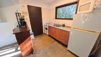 a kitchen with a white refrigerator and a sink at Demeter in Las Chacras (La Paz)