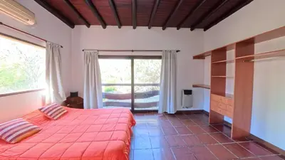 a bedroom with a red bed and a large window at Demeter in Las Chacras (La Paz)
