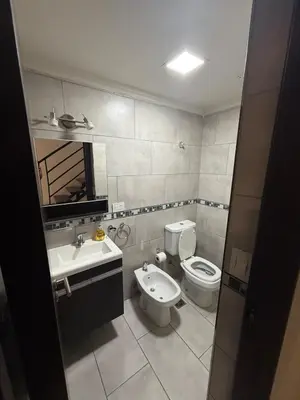a bathroom with a toilet and a sink at Triplex Premium in Villa Carlos Paz