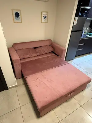 a brown couch in a room with a kitchen at Triplex Premium in Villa Carlos Paz