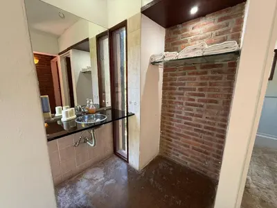a bathroom with a brick wall and a sink at Atlas in Las Chacras (La Paz)