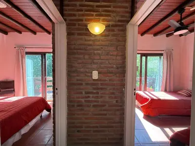a bedroom with two beds and a brick wall at Atlas in Las Chacras (La Paz)