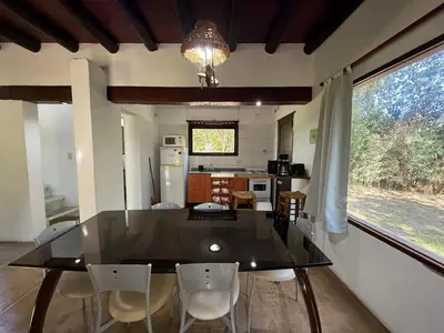 a dining room and kitchen with a glass table and chairs at Atlas in Las Chacras (La Paz)