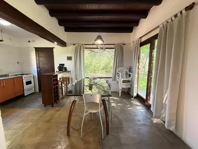 a dining room with a table and chairs and a kitchen at Atlas in Las Chacras (La Paz)
