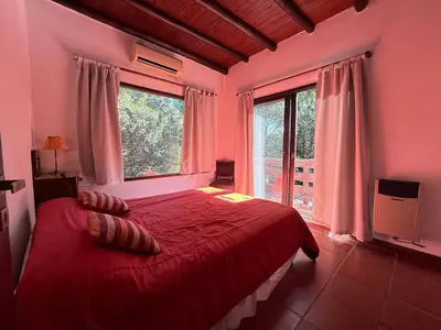 a bedroom with a red bed and a large window at Atlas in Las Chacras (La Paz)