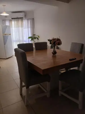 a wooden table with chairs and a vase of flowers on it at Corazón de nva cba in Cordoba