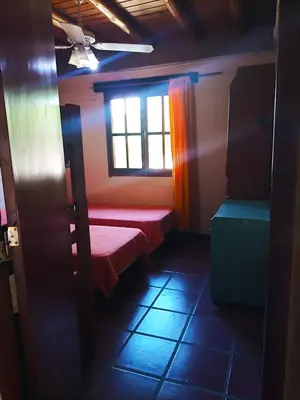 a room with a red bed and a window at Caburé in Mina Clavero