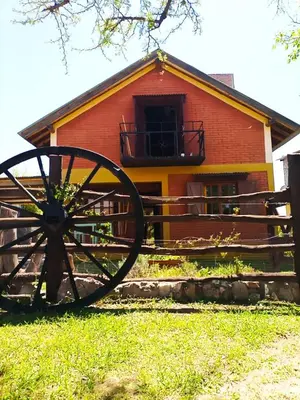 a wooden barn with a large wheel in front of it at Caburé in Mina Clavero