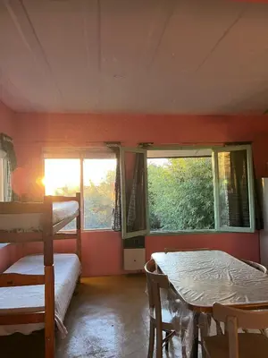 a room with two bunk beds and a table and a window at Caburé in Mina Clavero