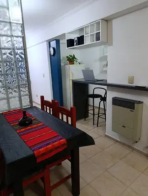 a living room with a table and a kitchen at Balcones de Alberdi in Cordoba