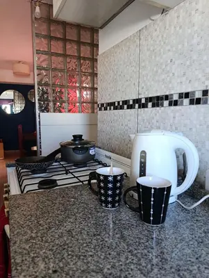 a kitchen with a stove and two cups on a counter at Balcones de Alberdi in Cordoba