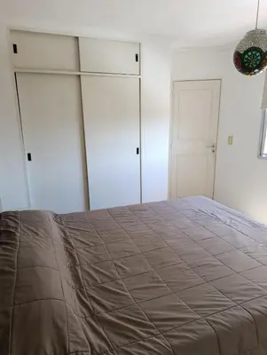 a bedroom with white cabinets and a large bed at Balcones de Alberdi in Cordoba