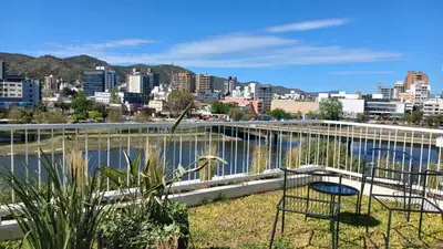 a chair sitting on a balcony with a view of a city at ALOJATE PREMIUM VILLA CARL0S PAZ - Stefano 2 dor in Villa Carlos Paz