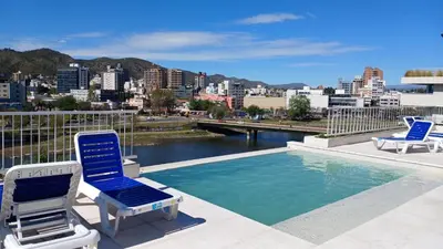 two chairs and a swimming pool on top of a building at ALOJATE PREMIUM VILLA CARL0S PAZ - Stefano 2 dor in Villa Carlos Paz