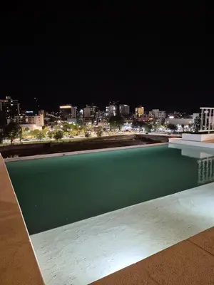 a swimming pool with a view of a city at night at ALOJATE PREMIUM VILLA CARL0S PAZ - Stefano 2 dor in Villa Carlos Paz