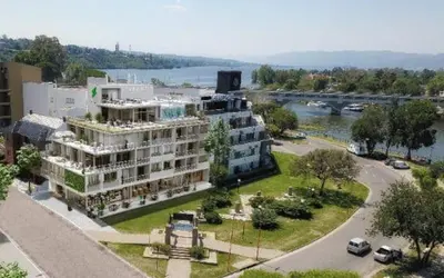 a large apartment building next to a river with cars at ALOJATE PREMIUM VILLA CARL0S PAZ - Stefano 2 dor in Villa Carlos Paz