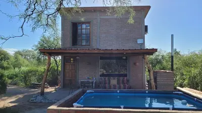a house with a swimming pool in front of a house at Cabañas Sacha Huasi in Travesía