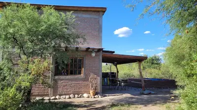 a brick house with a table and a bench outside at Cabañas Sacha Huasi in Travesía