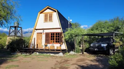 a small house with a truck parked in front of it at Cabañas Sacha Huasi in Travesía