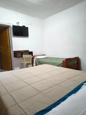 a bedroom with a bed and a tv on the wall at Hostería Champaquí in Los Hornillos